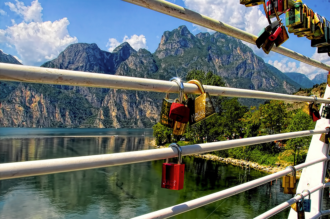 security locks on bridge with mountains in the background