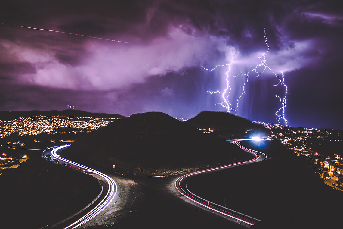 lightening strking in background of highway
