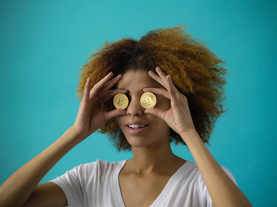 woman holding bitcoin to her eyes looking at wordpress themes