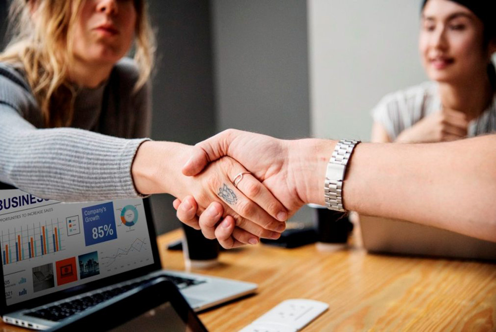 shaking hands over computer