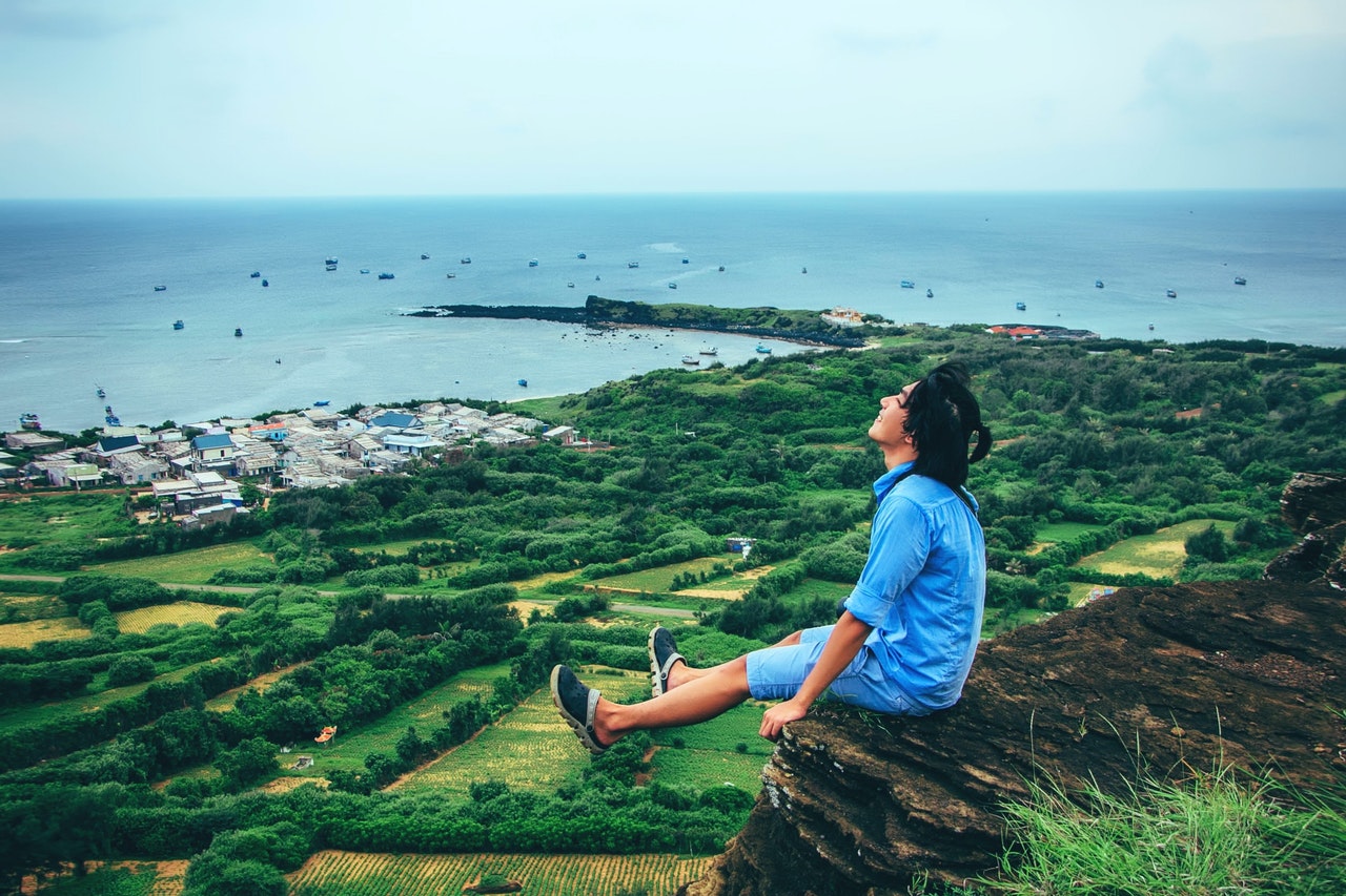 man sitting on cliff relaxing due to never running out of content ideas